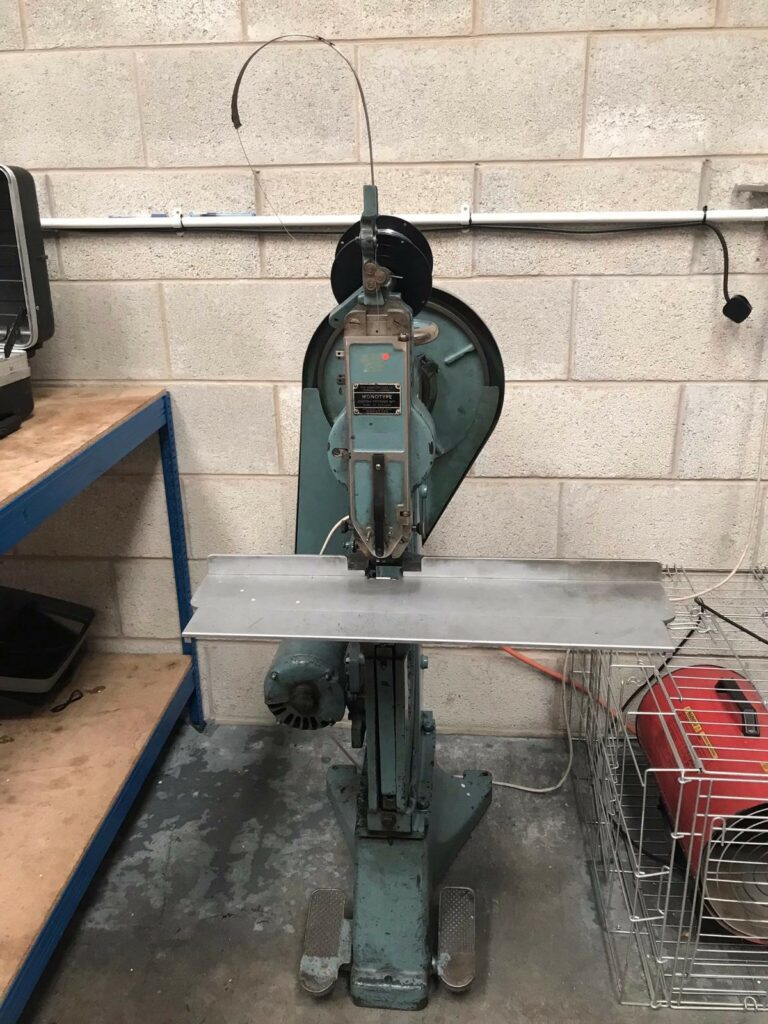 CLC | A Refurbished Monotype Boston No7 Wire Stitcher machine is sitting on a table in a garage.